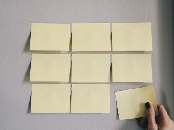 des post-its blancs déposés en puzzle avec une main féminine qui colle le dernier