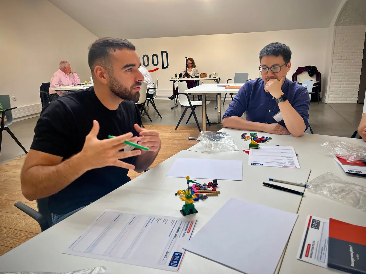 Deux managers échangent en sous-groupe pendant la journée Manager sans piloter, Goood!